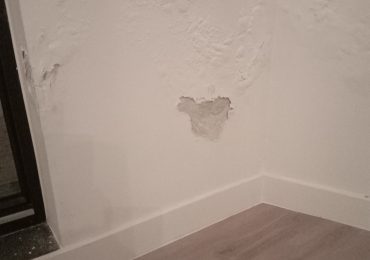 Binnenmuur van een nieuw gebouw met zichtbare schade door vochtproblemen