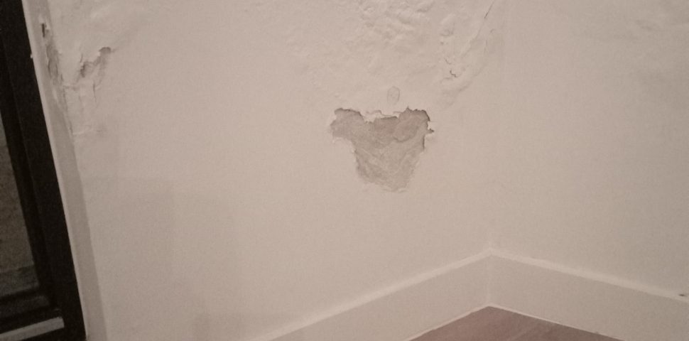 Binnenmuur van een nieuw gebouw met zichtbare schade door vochtproblemen