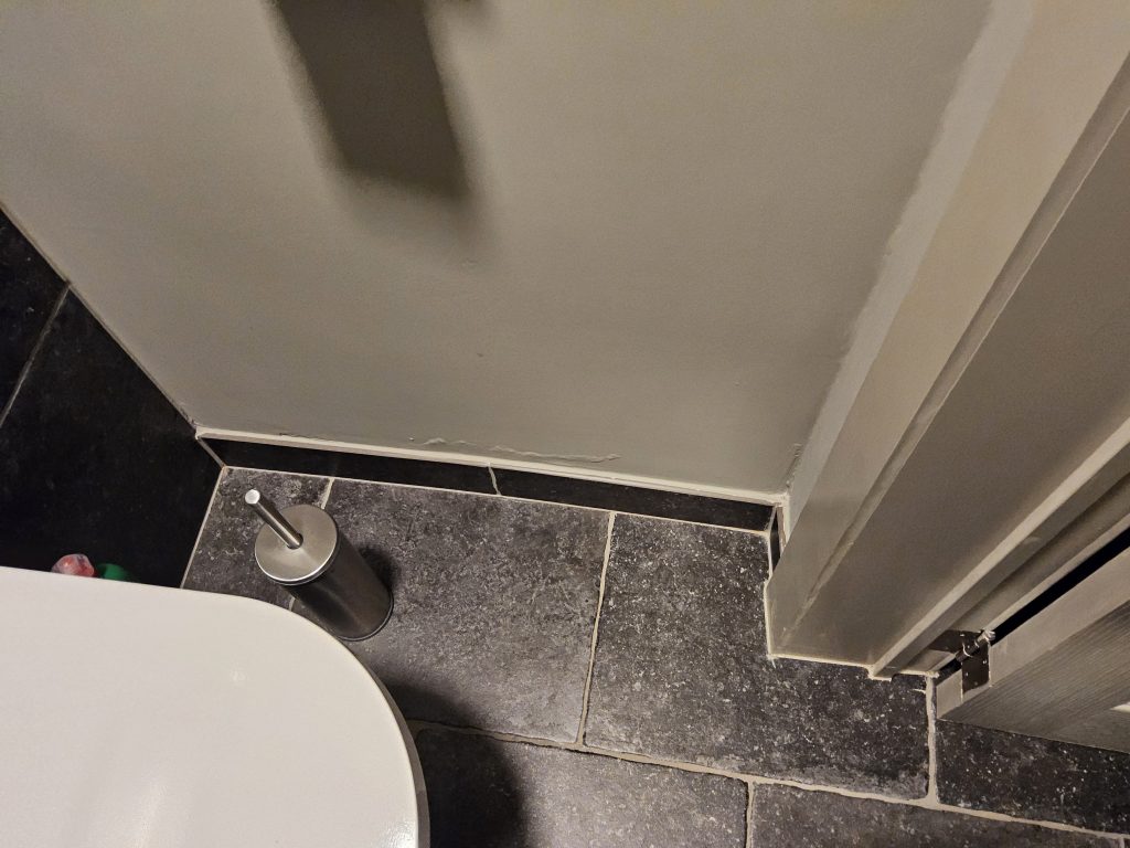Vochtige badkamer met afbladderende verf
