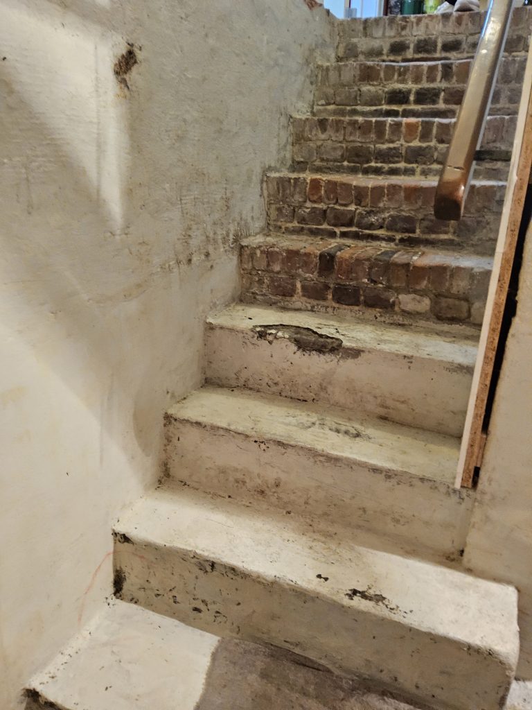 Vochtige keldertrap die nood heeft aan vochtbestrijding van muren en treden